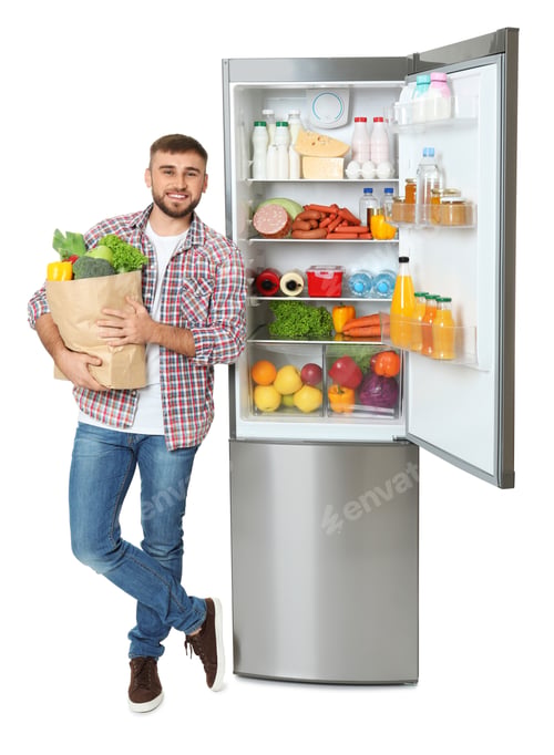Preview: Young man with bag of groceries near open refrigerator on white background