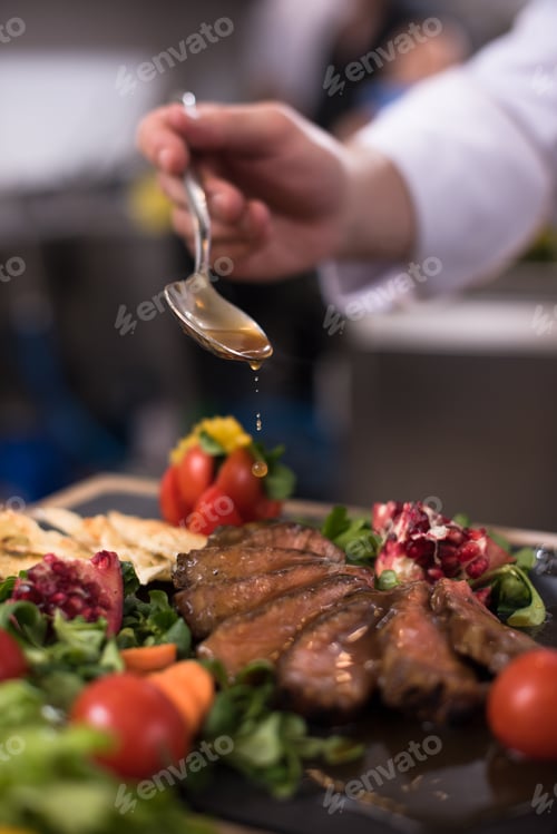 Preview: Chef hand finishing steak meat plate