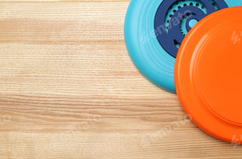 Preview: Plastic frisbee disks on wooden background, flat lay. Space for text