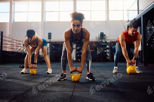 Preview: Group of athletes exercising with kettle bell in health club