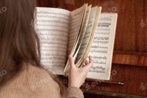 Preview: The woman at the piano leafs through a collection of notes.