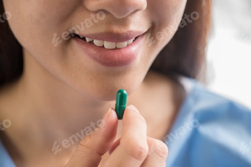 Preview: Young woman taking medicine pill after doctor order
