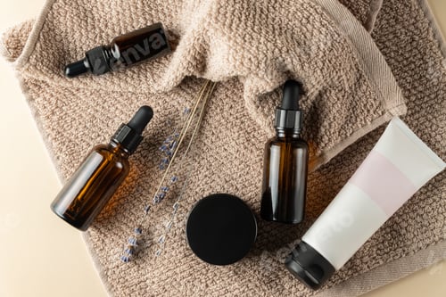 Preview: Set of natural organic SPA beauty products on brown towel. Homemade face oil, moisturizer cream jar