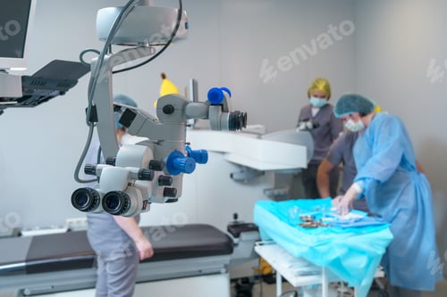 Preview: Surgical microscope in operating room with doctors. Ophthalmological clinic