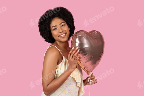 Preview: African American woman hugging a heart-shaped balloon lovingly
