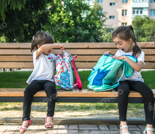 Preview: Happy cute industrious kids sitting on the bench and talking.