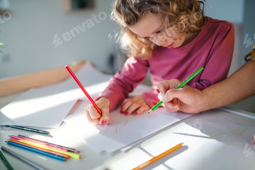 Preview: A cute small girl with mother indoors at home, drawing pictures