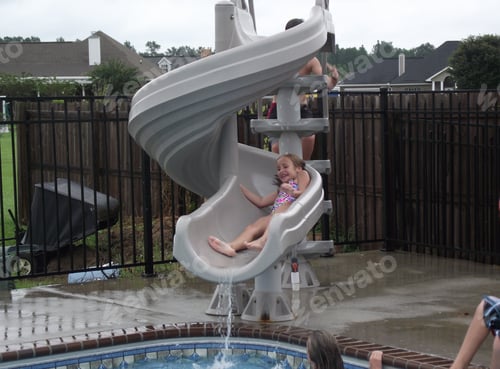 Preview: Girl Playing on Water Slide by the Pool
