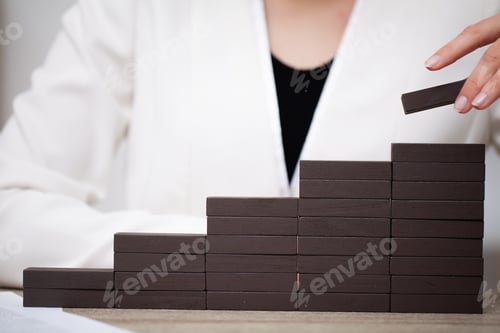 Preview: Female hand arranging wood block stacking as step stair