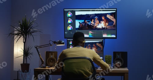 Preview: Medium Shot Of A Young Man Sitting Back And Editing A Video Inside A Modern Video Studio