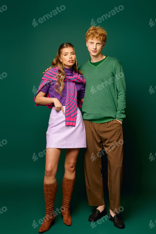 Preview: Young couple radiates style and love in vibrant attire against a bold green backdrop