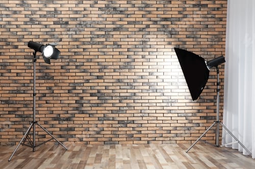Preview: Professional lighting equipment near wall in photo studio. Space for text