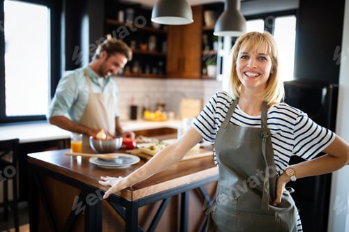 Preview: Happy couple preparing food in the kitchen