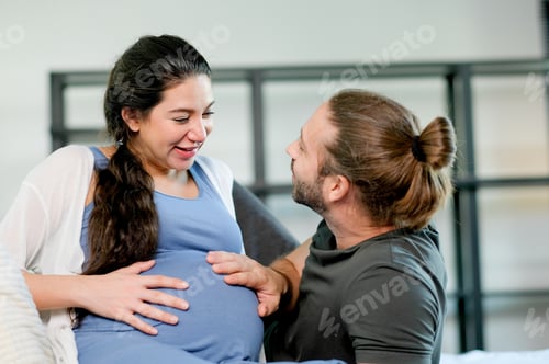 Preview: Pregnant woman lie on bed to relax and look at her husband with love and happy emotion