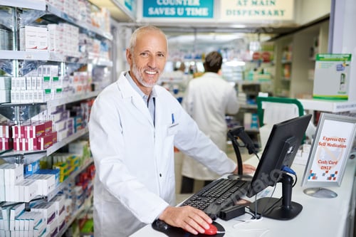 Preview: Portrait of a mature pharmacist working on a computer in a chemist