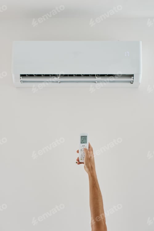 Preview: Hand Holding Remote Control to Set Temperature on Wall Air Conditioner