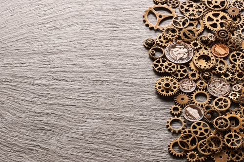 Preview: Various metal cogwheels with USA coins