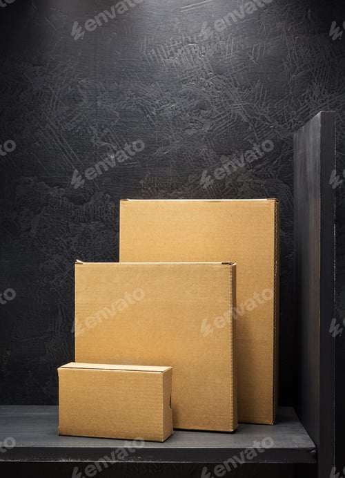 Preview: Three cardboard boxes in front of a textured wall