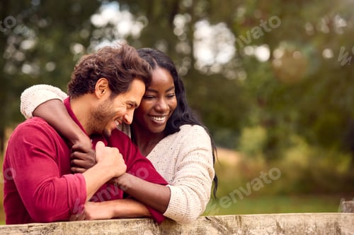 Preview: Loving Mixed Race Couple Leaning On Fence On Walk In Countryside