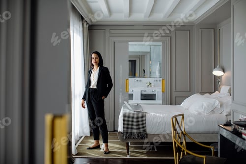 Preview: Confident businesswoman standing in an elegant hotel room