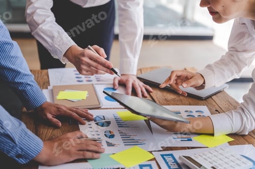 Preview: Young colleagues discussing business and price chart analyzes business people on the table great in