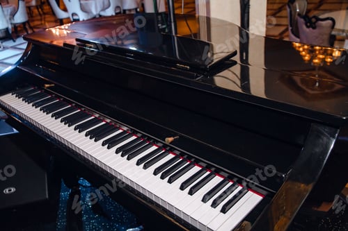 Preview: Close-up of a black piano in a restaurant with black and white piano keys.