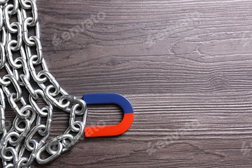 Preview: Magnet attracting chain on dark grey wooden background, flat lay. Space for text