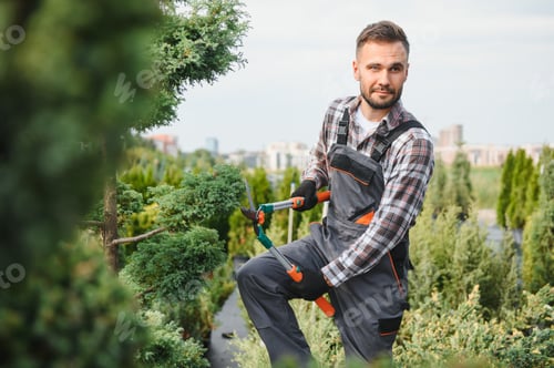 Man Trimming Plants in a Garden Center