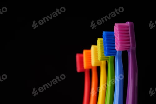 Preview: Multicolored plastic toothbrushes on a black background.