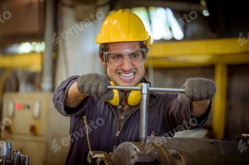 Preview: Engineer worker wearing safety uniform control operating computer controlled Lathe grinding machine