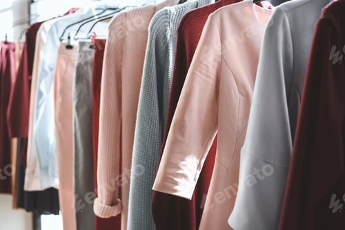 Preview: different trendy clothes hanging on hangers in boutique