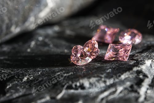Preview: Glimmering natural pink sapphire gemstones on a rugged rock surface