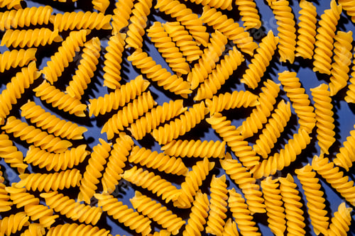 Preview: Pasta dry spiral italian yellow on blue background pattern.