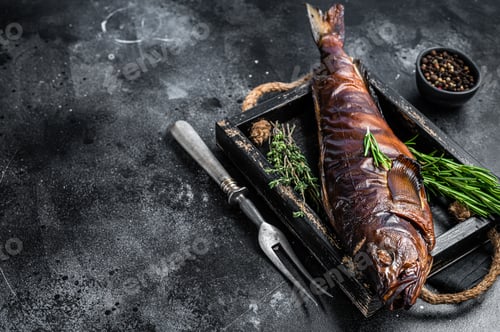 Preview: Hot smoked pike perch or zander fish in a wooden tray. Black background. Top view. Copy space