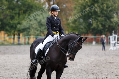 Preview: Young teenage girl riding raven horse on dressage equestrian event