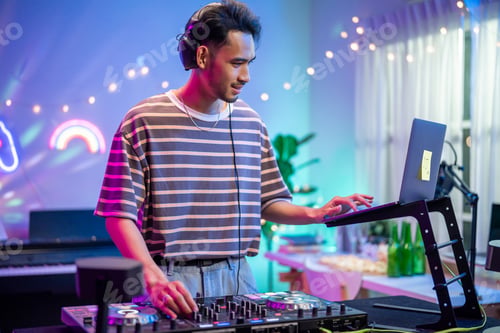 Preview: Asian young man artist DJ mixing and scratching music mixer controller.