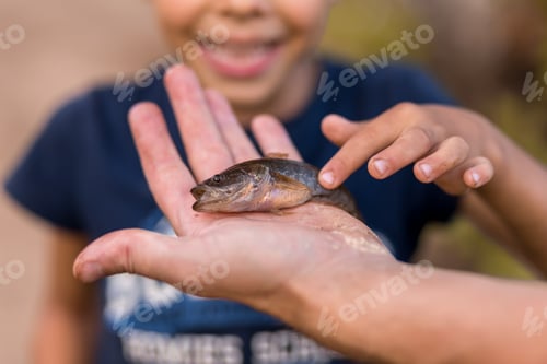 Preview: a boy of 6-7 years old rejoices at a fish caught on the lake