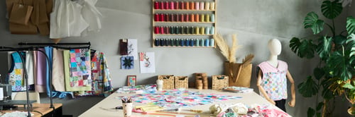 Preview: Sewing Studio Table Displaying Patchwork Quilt Projects and Colorful Threads