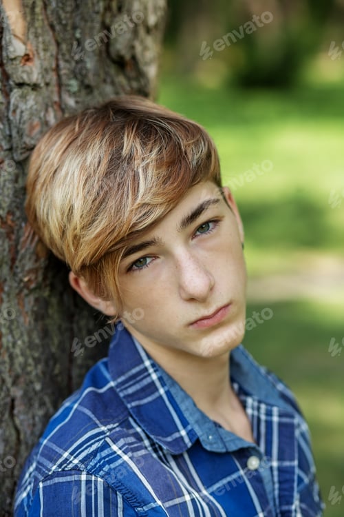 Preview: Close-up portrait of a teenager boy outdoors. Gen Z. Identity development.