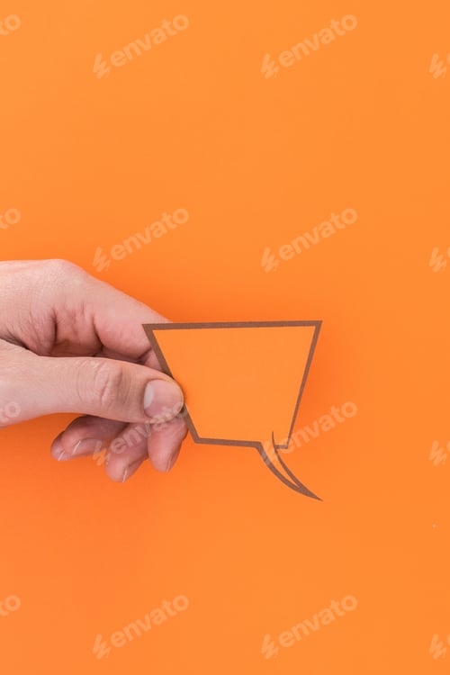 Preview: Vertical shot of a person holding a speech bubble icon isolated on an orange background