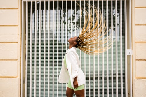 Preview: Portrait of an african woman waving her hair making a circle shape on the air
