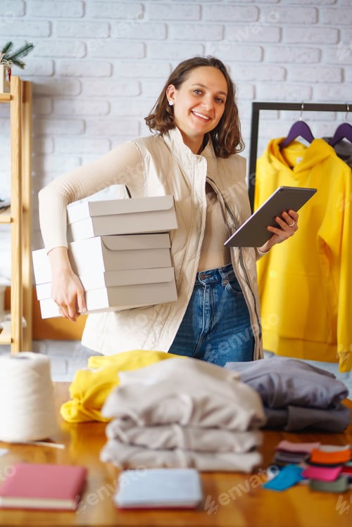 Preview: Small business owner, entrepreneur, seller using tablet checking ecommerce clothing store orders.