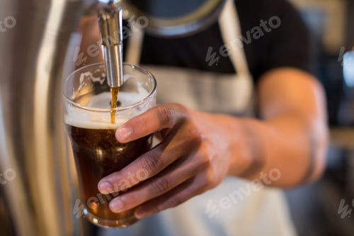 Preview: Midsection bartender pouring beer from tap