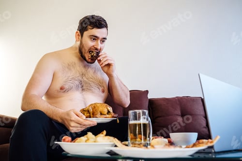 Preview: portrait of a caucasian fat man eating chicken grill on the sofa. looking at camera,