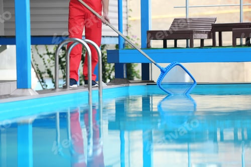 Preview: Male worker cleaning outdoor pool with scoop net