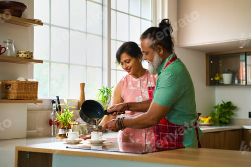 Preview: Indian husband serves tea to surprised wife in the kitchen, showing love and care