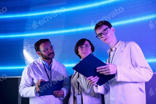 Preview: forward-thinking, young intern looking away near multiethnic scientists in innovation hub