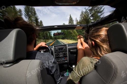 Preview: Rear view of young couple on the road in jeep