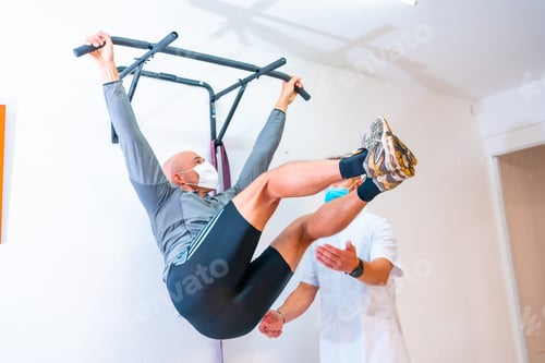 Preview: Healthcare professional guiding the patient at the rehabilitation gym with masks on