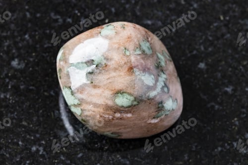 Preview: tumbled Nunderite (Nundorite) on black granite
